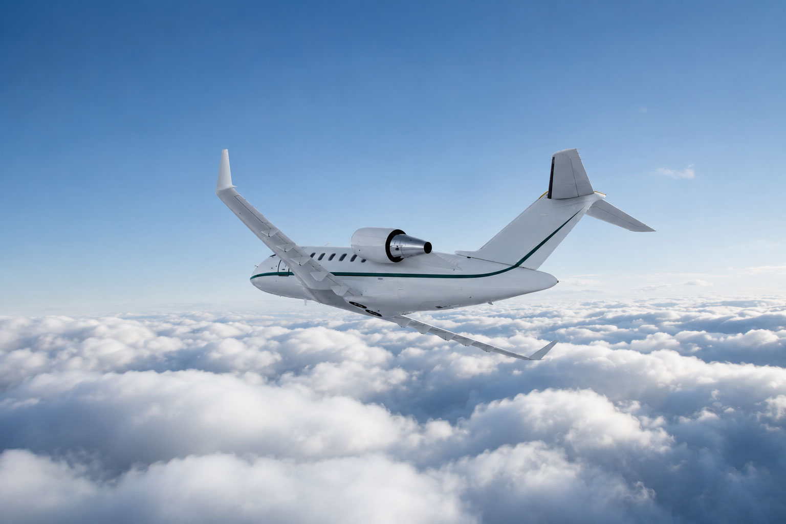 White business jet with green accents flying above a layer of soft clouds, viewed from behind, representing modern business aviation and long-range performance.