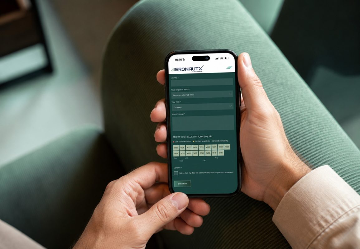Hand holding a smartphone with a pilot training inquiry form displayed, representing the digital booking process for aviation courses