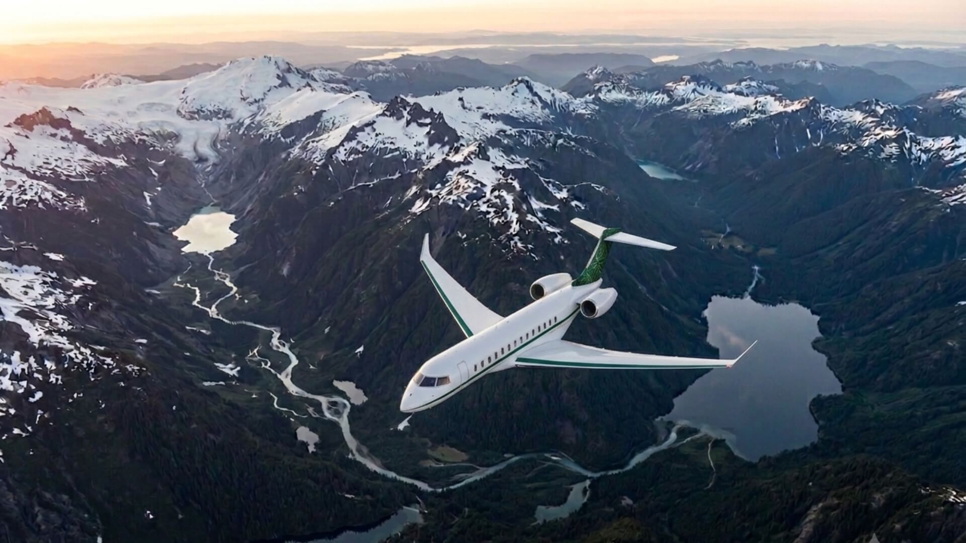 White business jet with green accents flying above mountains and lakes under a clear sky, showcasing premium business aviation and long-range performance.